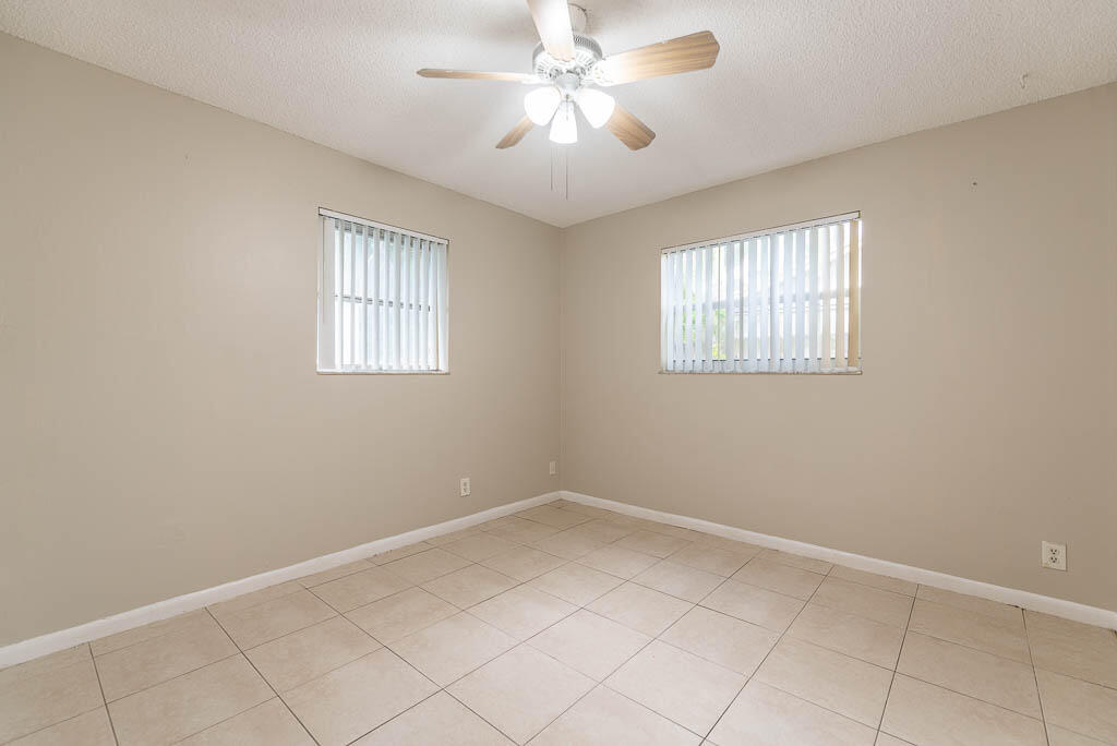 10225 Sleepy Brook Way Boca Raton, FL 33428 - Photo 18 of 41 a view of an empty room with a window and a chandelier fan