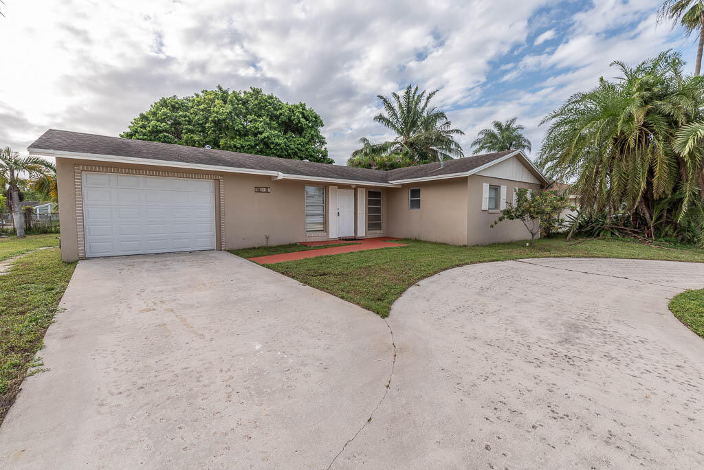 10225 Sleepy Brook Way Boca Raton, FL 33428 - Photo 41 of 41 front view of a house with a yard and potted plants