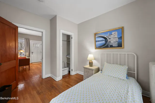 a bedroom with a bed and a painting on the wall