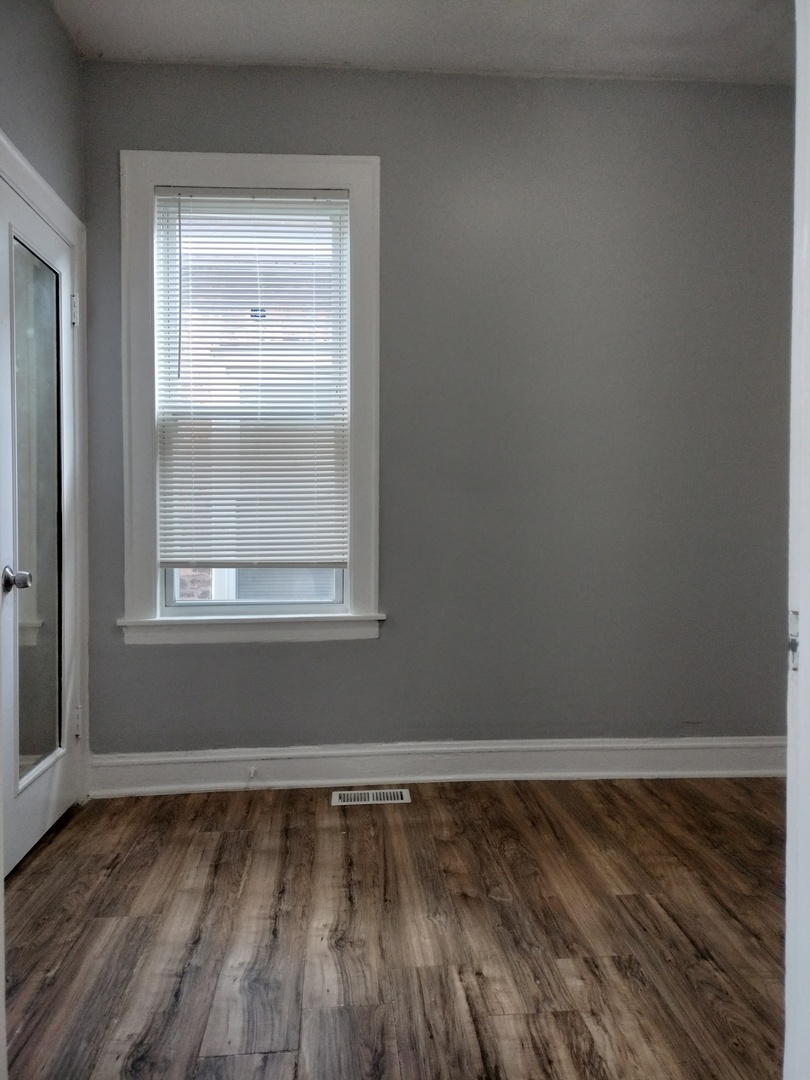 705 East 92nd Street Chicago, IL 60619 - Photo 13 of 23 a view of a room with wooden floor and window