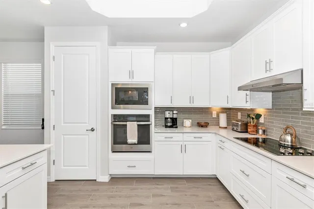 a living room with furniture a flat screen tv and a view of kitchen