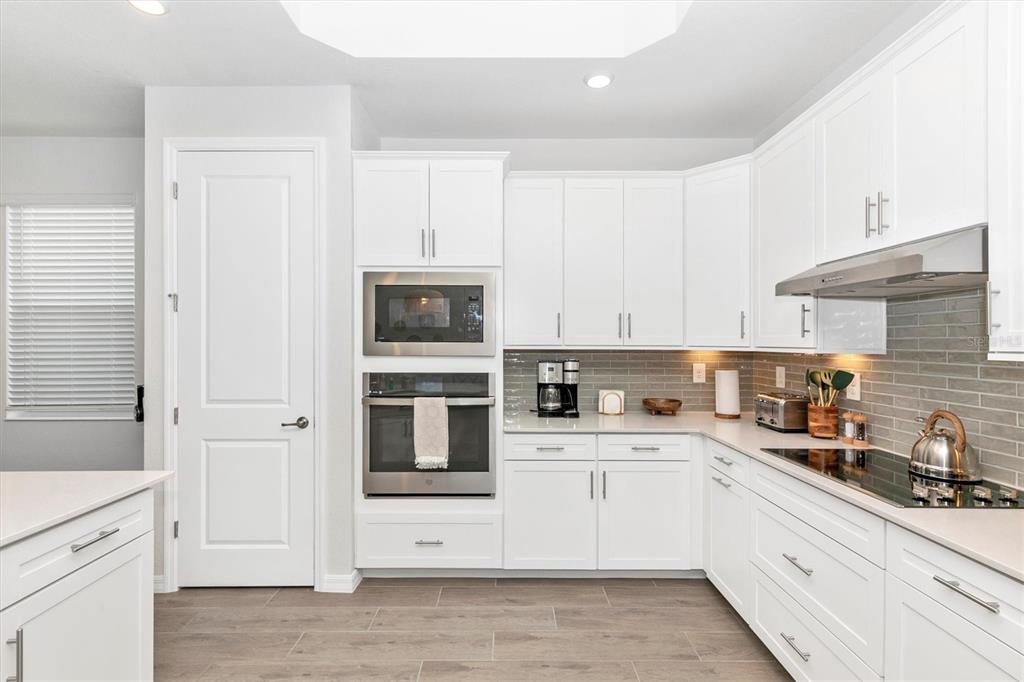 17672 Santorini Court Venice, FL 34293 - Photo 13 of 94 a kitchen with granite countertop white cabinets and white appliances