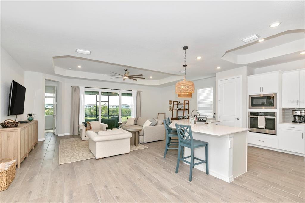 17672 Santorini Court Venice, FL 34293 - Photo 17 of 94 a living room with furniture a flat screen tv and a large window