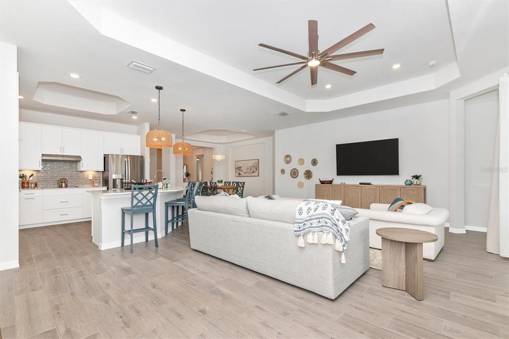 17672 Santorini Court Venice, FL 34293 - Photo 19 of 94 a living room with furniture a flat screen tv and a view of kitchen