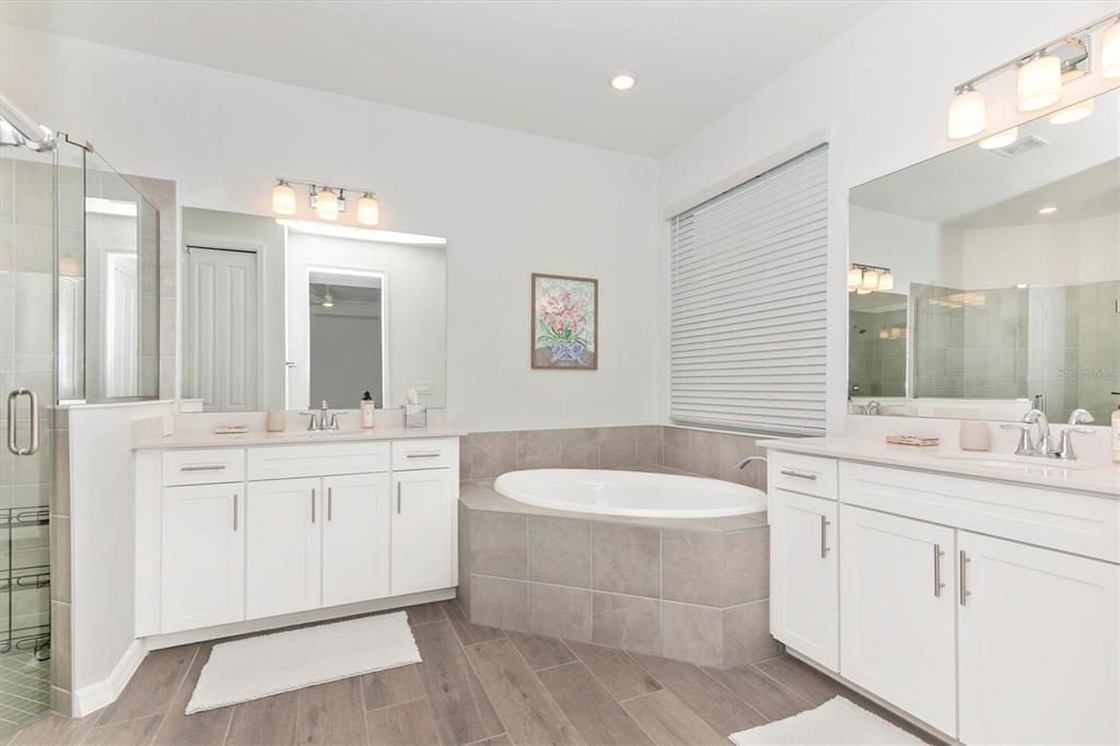 17672 Santorini Court Venice, FL 34293 - Photo 30 of 94 a bathroom with a double vanity sink a toilet a mirror and bathtub