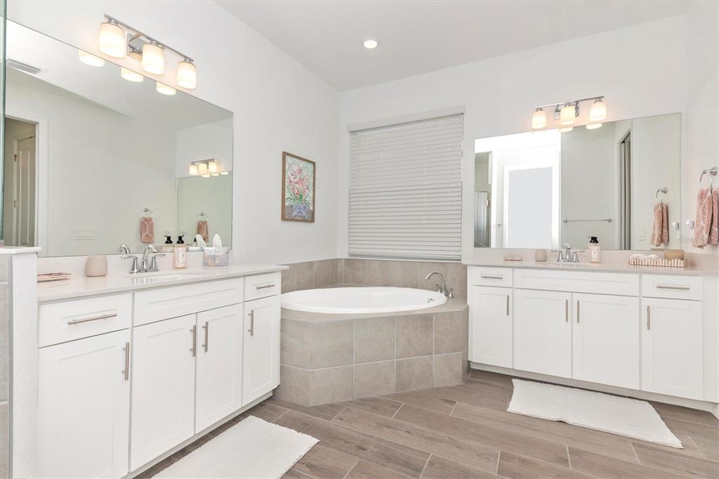 17672 Santorini Court Venice, FL 34293 - Photo 31 of 94 a bathroom with a sink double vanity mirror and a bathtub
