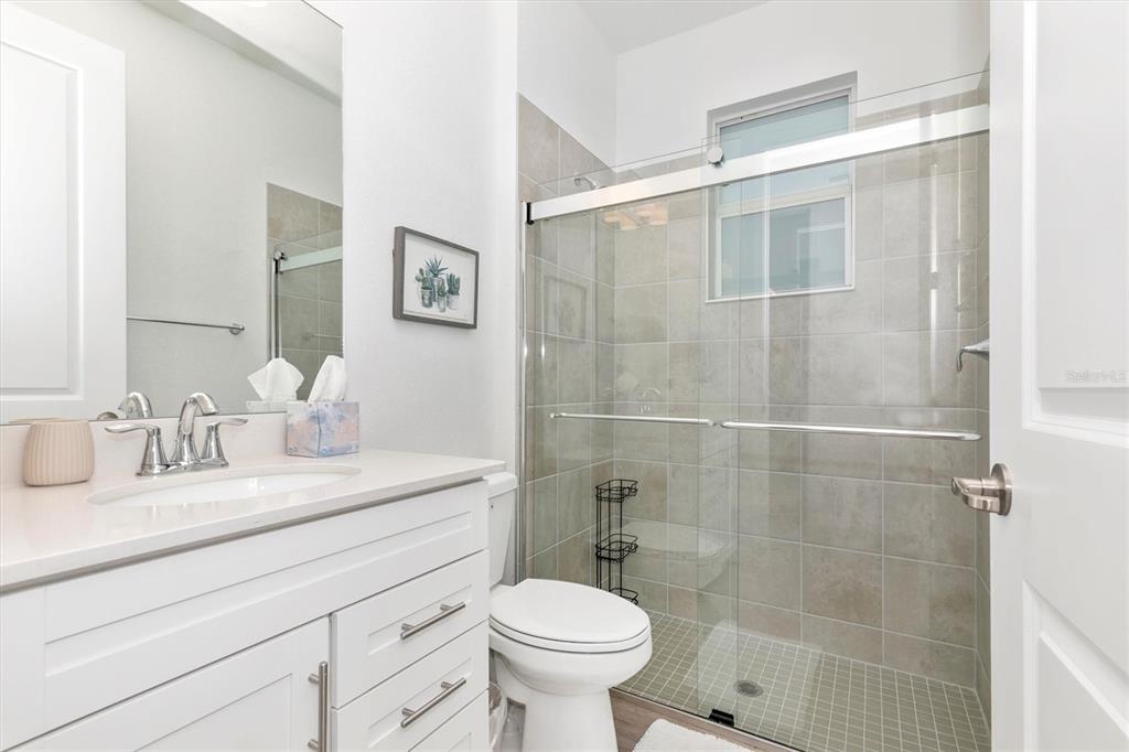 17672 Santorini Court Venice, FL 34293 - Photo 39 of 94 a bathroom with a toilet sink vanity and mirror