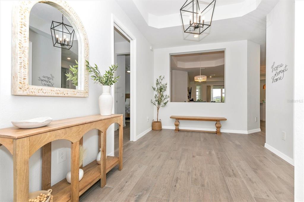 17672 Santorini Court Venice, FL 34293 - Photo 4 of 94 a view of a room with wooden floor and a potted plant