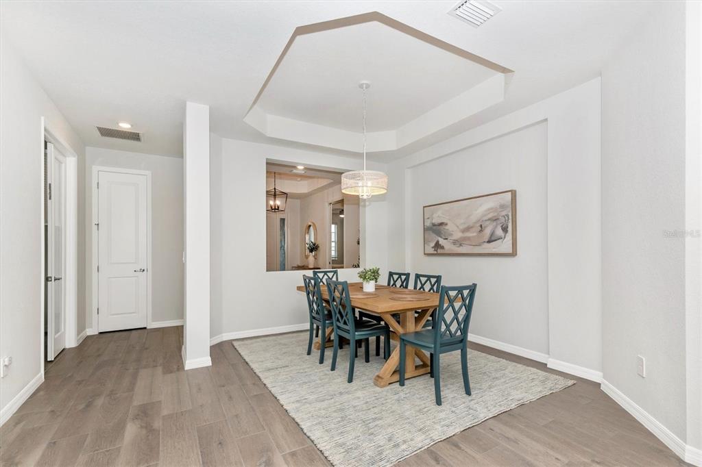17672 Santorini Court Venice, FL 34293 - Photo 5 of 94 a view of a dining room with furniture and wooden floor