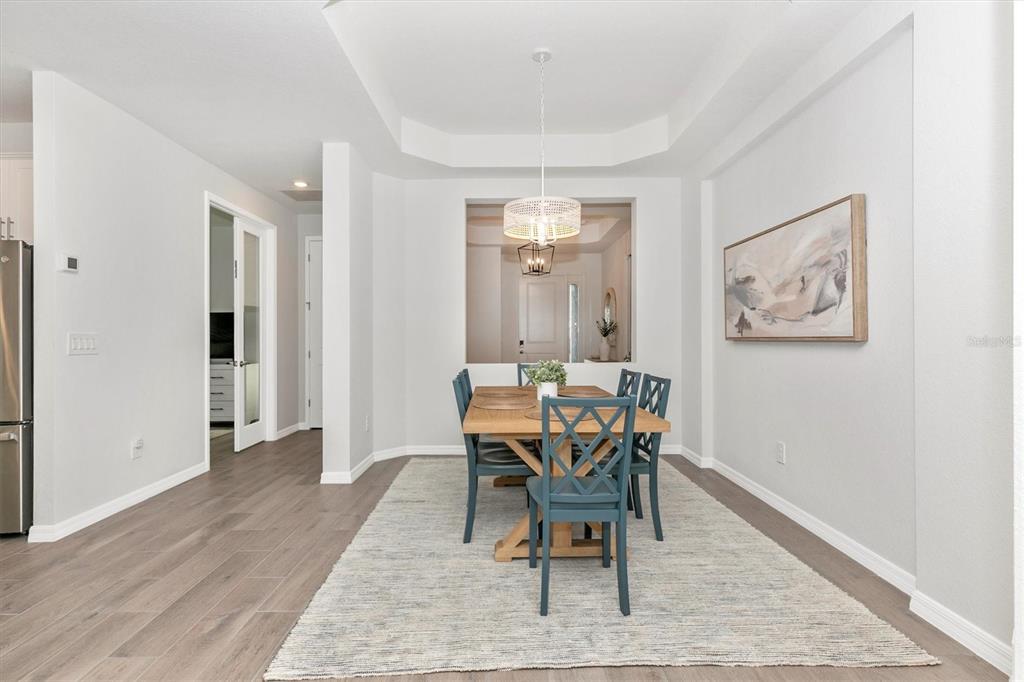 17672 Santorini Court Venice, FL 34293 - Photo 6 of 94 a dining room with wooden floor and a rug