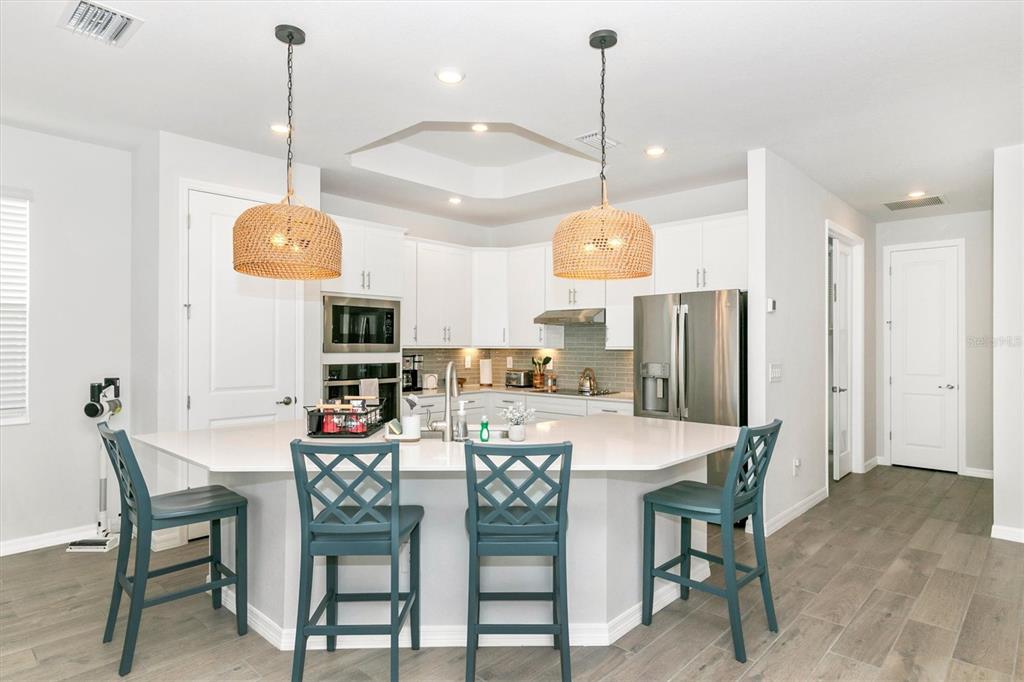 17672 Santorini Court Venice, FL 34293 - Photo 10 of 94 a kitchen with stainless steel appliances kitchen island granite countertop a table and chairs