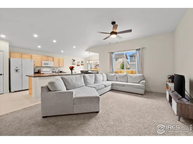 a living room with furniture and a view of kitchen
