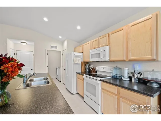 a kitchen with granite countertop a sink stainless steel appliances and cabinets