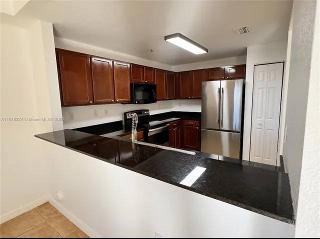 a kitchen with stainless steel appliances a refrigerator a stove a microwave and cabinets