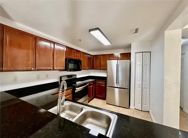 a kitchen with stainless steel appliances granite countertop a refrigerator and a sink