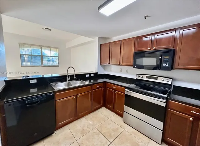 a kitchen with granite countertop stainless steel appliances and sink