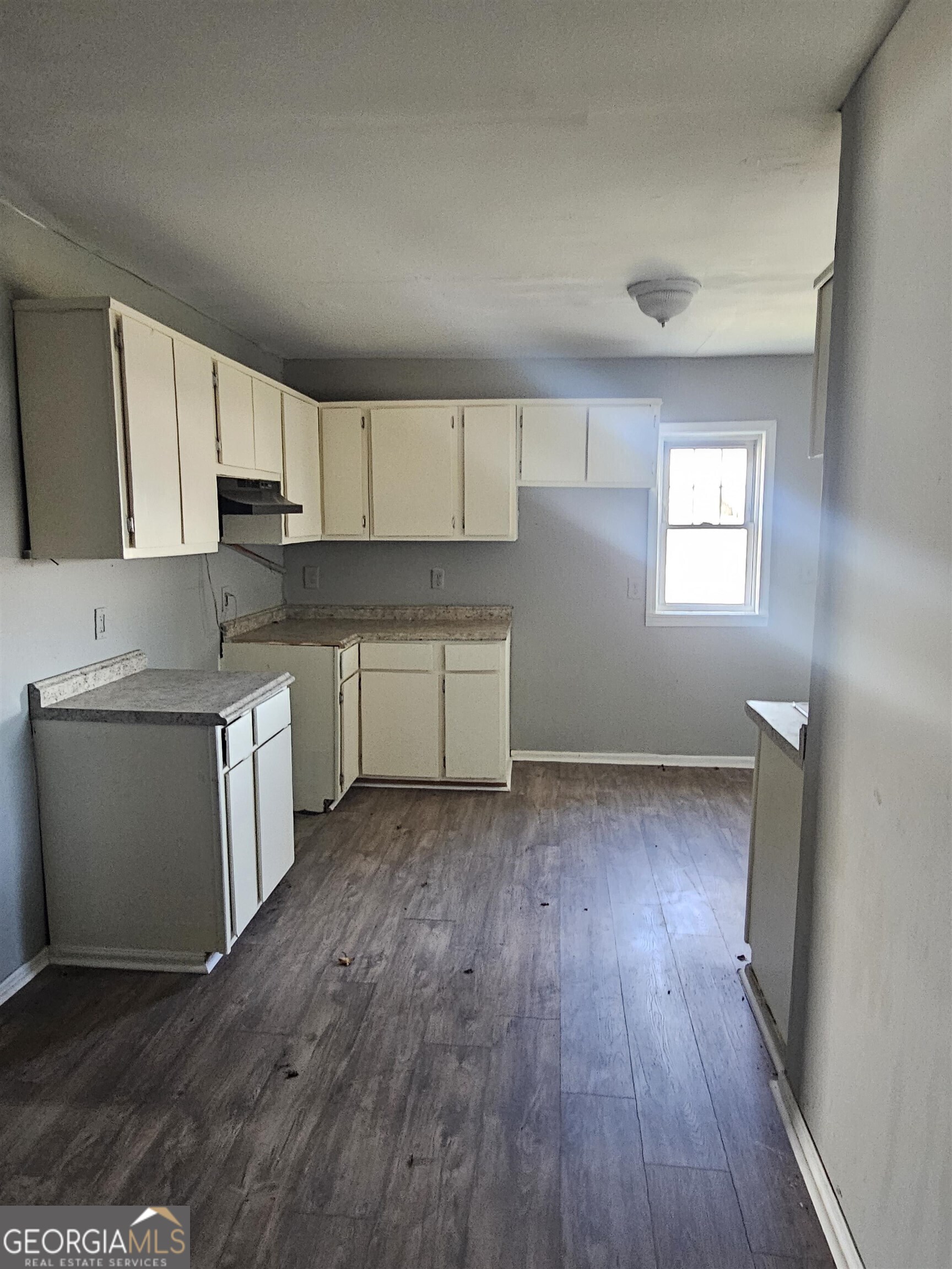 132 Madison Street Macon, GA 31201 - Photo 4 of 4 a kitchen with wooden floors and white stainless steel appliances