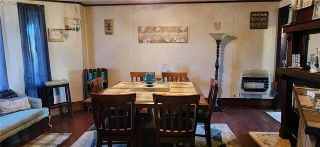 a kitchen that has a table chairs in it and wooden cabinets