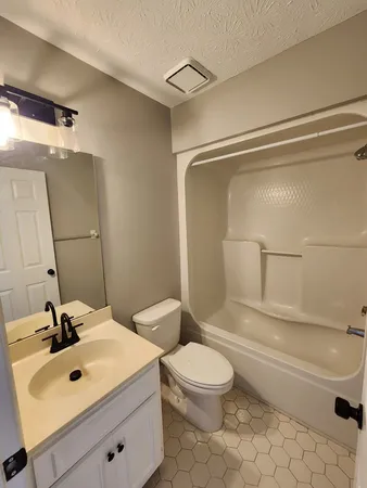 a bathroom with a sink mirror vanity and toilet