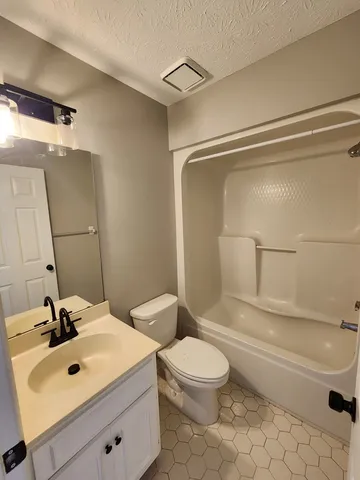 a bathroom with a sink mirror vanity and toilet