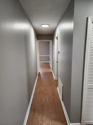 a view of a hallway with wooden floor