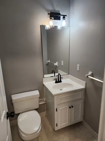 a bathroom with a toilet sink and mirror