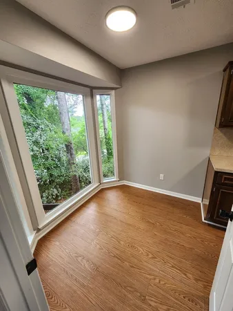 a view of a room with wooden floor and a window