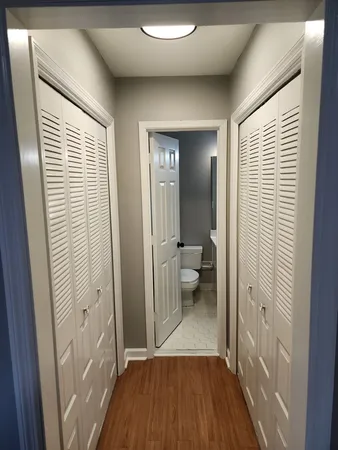 a view of a room with wooden floor and a bathroom