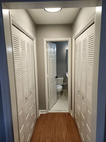 a view of a room with wooden floor and a bathroom