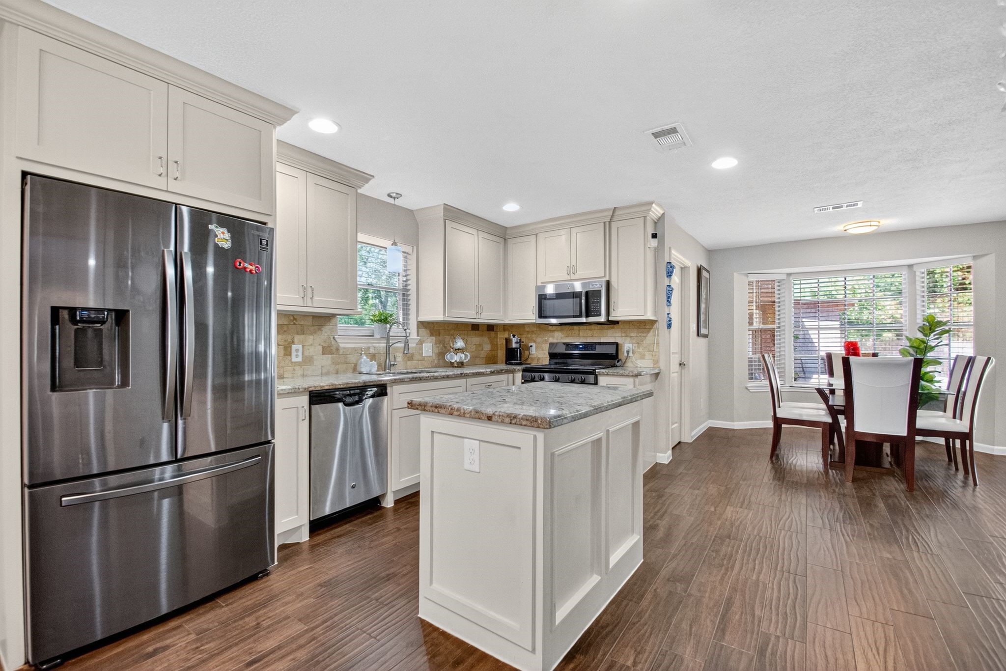 2514 Creekleaf Road Houston, TX 77068 - Photo 18 of 31 Kitchen designed for gathering, offering marble countertops, stainless steel finishes, gas range, and seamless connection to dining and living areas.