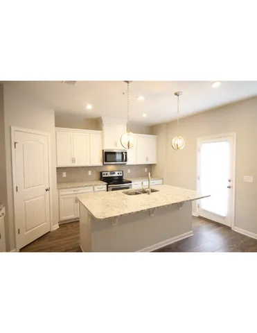 a open kitchen with a sink dishwasher a stove and a refrigerator with wooden floor