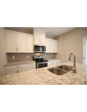 a kitchen with kitchen island granite countertop a sink stainless steel appliances and cabinets
