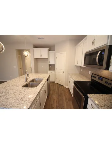 a kitchen with a sink dishwasher a stove and a microwave with island