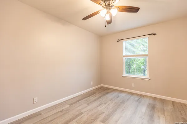 an empty room with a window and a fan