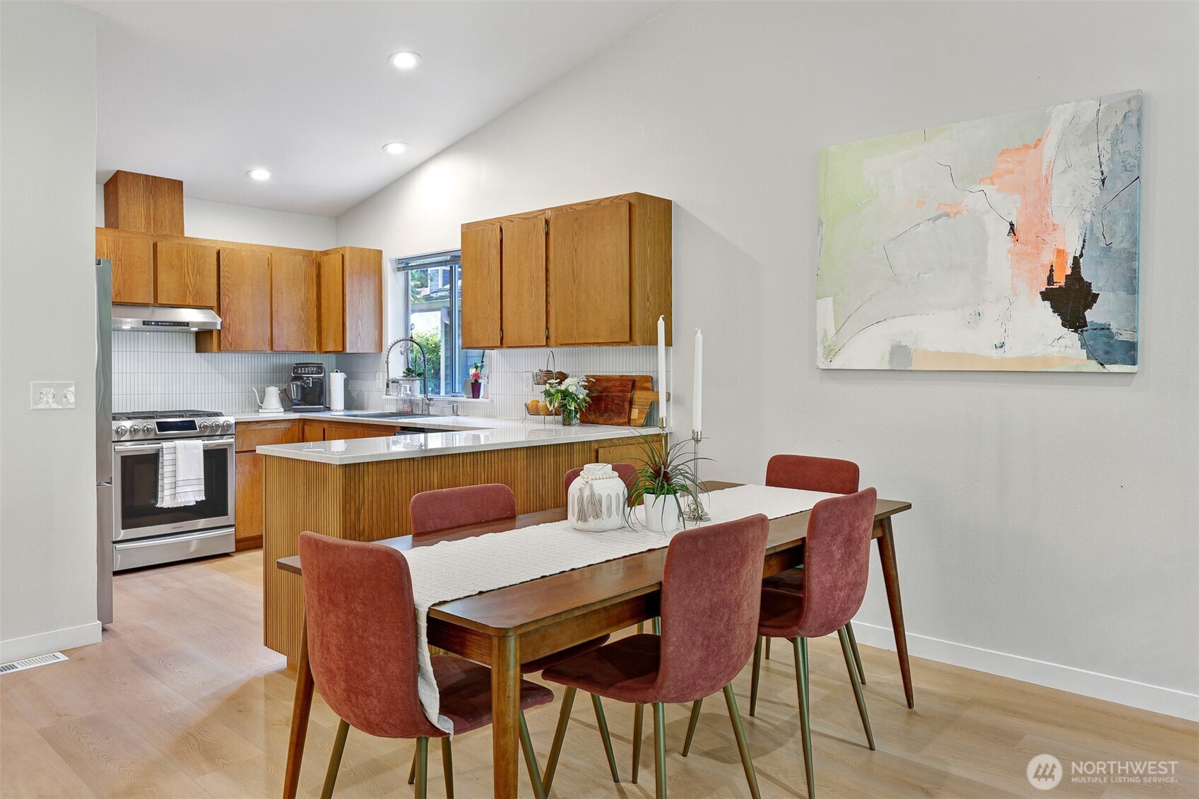 5126 South Garden Loop Road, Unit 11 Seattle, WA 98118 - Photo 10 of 36 a kitchen with a dining table chairs and a refrigerator