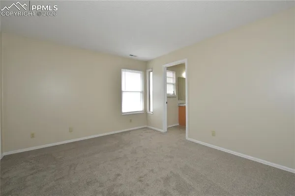 an empty room with windows and closet