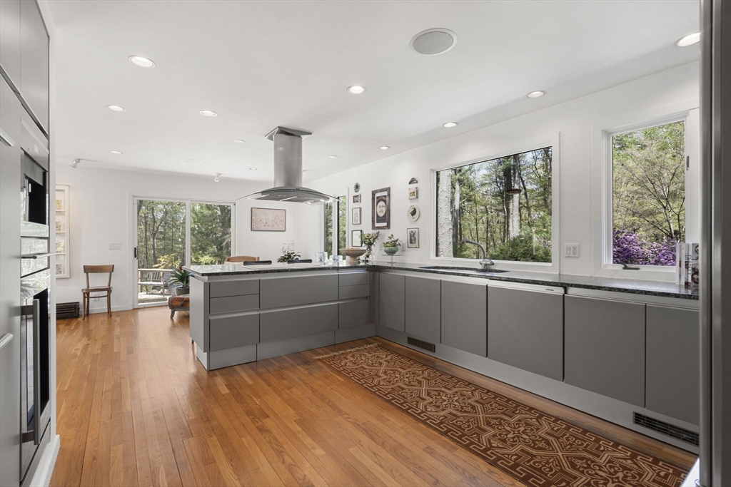 11 Chaplin Road Boxford, MA 01921 - Photo 11 of 42 a kitchen with stainless steel appliances granite countertop a stove a sink dishwasher and a large window with wooden floor