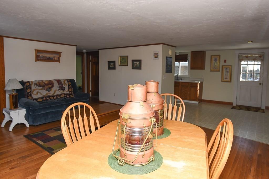156 Indian Neck Road Wareham, MA 02571 - Photo 6 of 18 a front view of a livingroom with furniture a fireplace and wooden floor