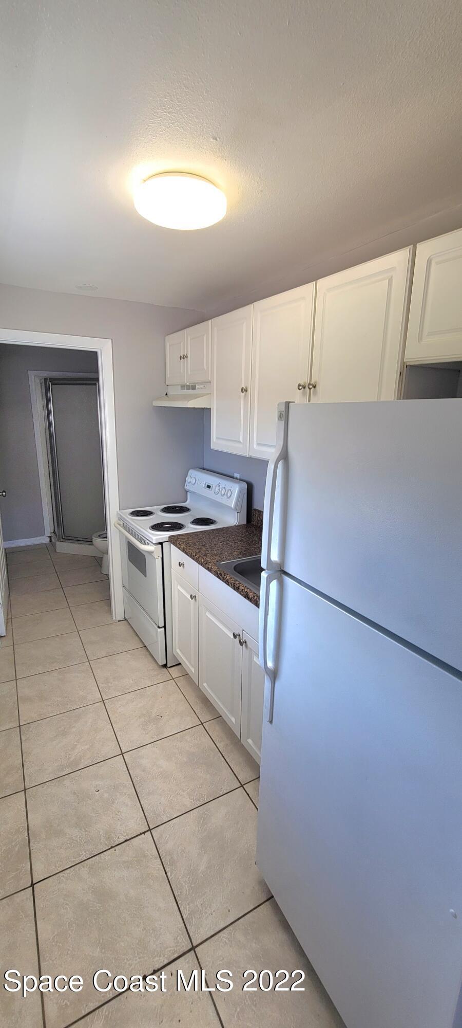802 Forrest Avenue, Unit A Cocoa, FL 32922 - Photo 8 of 16 a kitchen with a sink a stove and refrigerator
