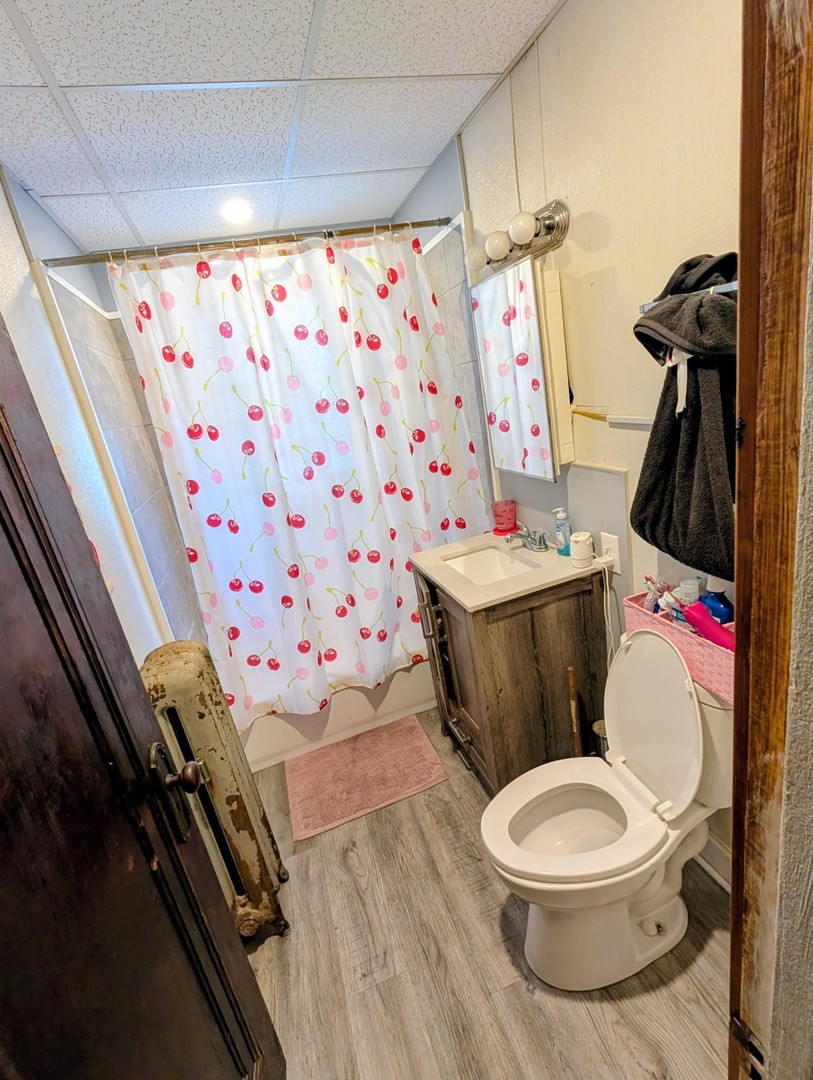 9035 South Bishop Street Chicago, IL 60620 - Photo 4 of 5 a white toilet sitting next to a bathroom sink and a mirror
