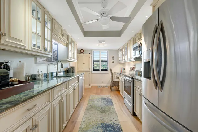 a kitchen with stainless steel appliances granite countertop a refrigerator and a sink