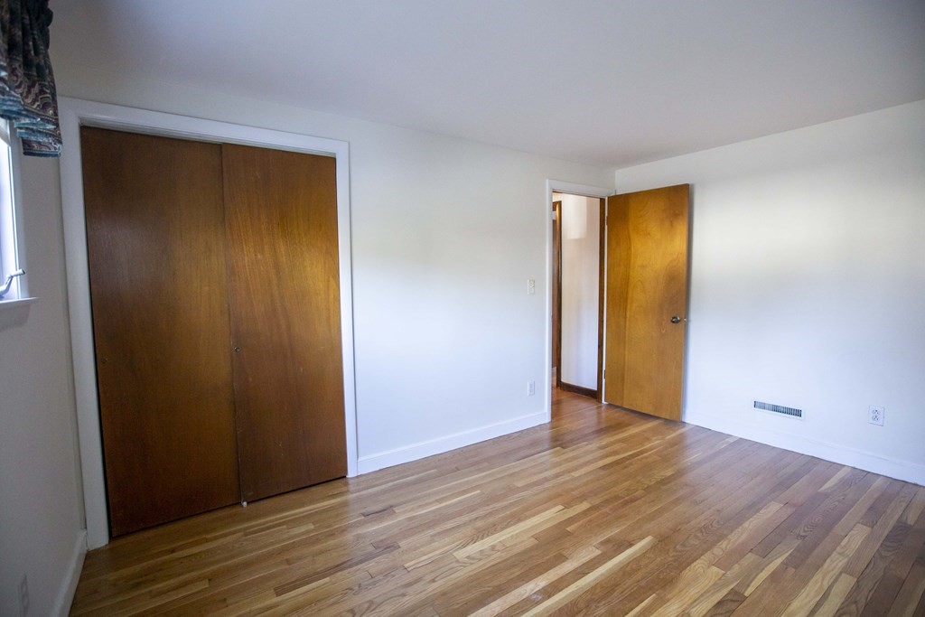 69 Sturges Road Reading, MA 01867 - Photo 11 of 42 a view of an empty room with wooden floor and closet
