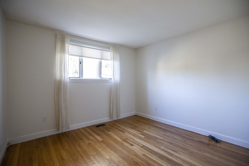 69 Sturges Road Reading, MA 01867 - Photo 12 of 42 an empty room with wooden floor and windows