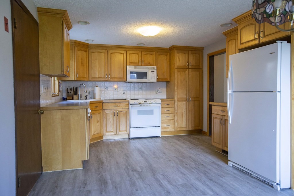 69 Sturges Road Reading, MA 01867 - Photo 14 of 42 a kitchen with a refrigerator a sink and dishwasher a oven with wooden floor