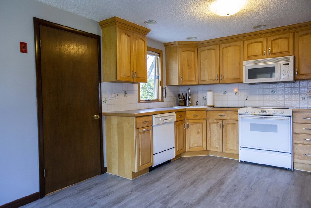 69 Sturges Road Reading, MA 01867 - Photo 15 of 42 a kitchen with a sink cabinets stainless steel appliances and wooden floor