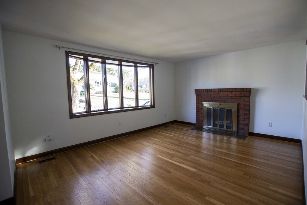 69 Sturges Road Reading, MA 01867 - Photo 4 of 42 a view of an empty room with wooden floor and a window