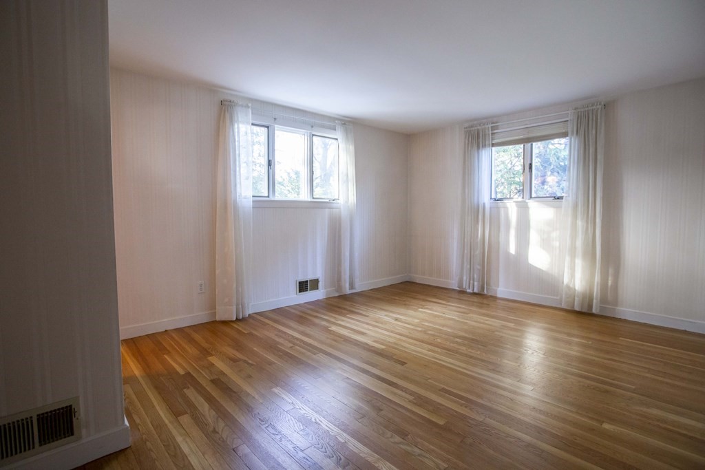 69 Sturges Road Reading, MA 01867 - Photo 7 of 42 a view of an empty room with wooden floor and a window