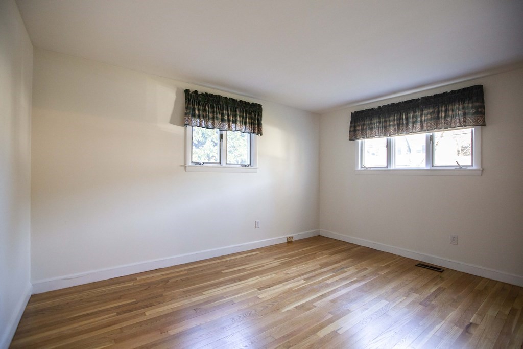 69 Sturges Road Reading, MA 01867 - Photo 10 of 42 a view of empty room with wooden floor and fan