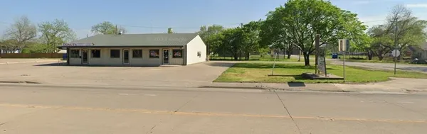 a view of a house with a yard and large trees