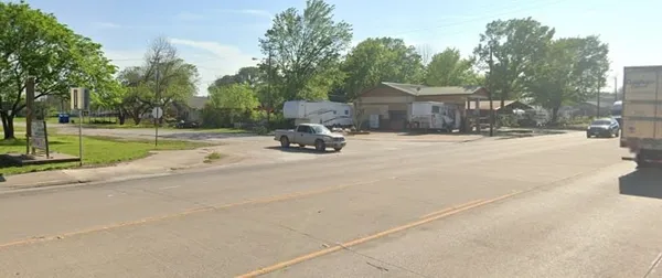 a view of a house with backyard and trees